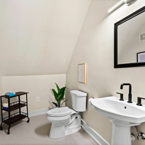 The upstairs features a half bath, as well as a separate shower stall and vanity.
