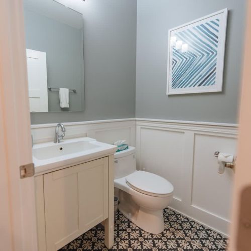 Convenient Half Bath: This stylish half bathroom is conveniently located off the main living area, ensuring easy access for guests. Featuring a modern design with a single vanity, ample storage, and a sleek toilet, this bathroom combines functionalit