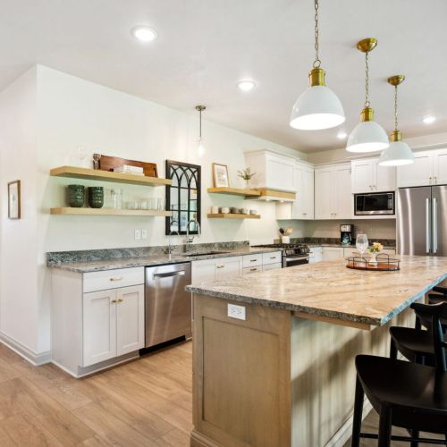 The fully equipped kitchen offers high-end appliances, a large center island, and plenty of room to cook and share stories while dining together at the table for eight.