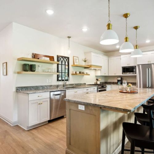The fully equipped kitchen offers high-end appliances, a large center island, and plenty of room to cook and share stories while dining together at the table for eight.