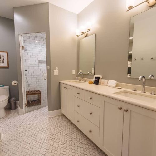 Step into this exquisite master bathroom, featuring high-end Kohler fixtures that blend functionality with elegance. The zero-entry shower provides a seamless transition, making it both accessible and stylish with its white subway tile. Dual vanities