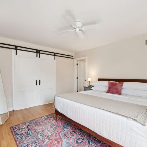 This first-floor bedroom features a king bed and sleek pocket doors that tuck away when open and easily close to create a cozy, quiet retreat.