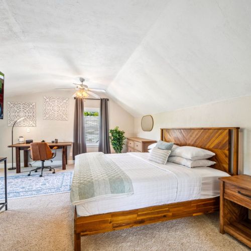 Retreat to the spacious upper-level main bedroom suite, featuring a luxurious king-sized bed and a dedicated workspace. This private oasis offers comfort and tranquility, perfect for relaxation and productivity.