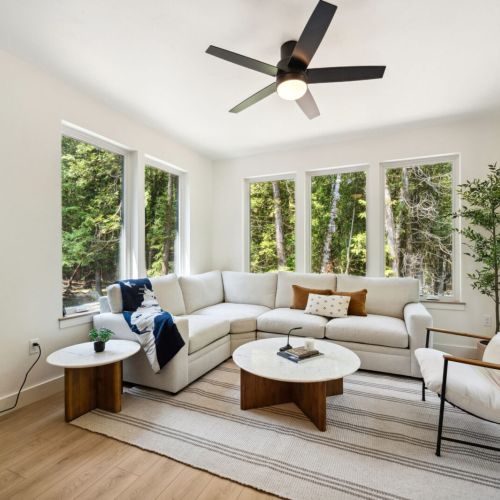 Surrounded by floor-to-ceiling windows, the four-season sunroom is the heart of the home. Enjoy the forest from the comfort of your plush sectional.