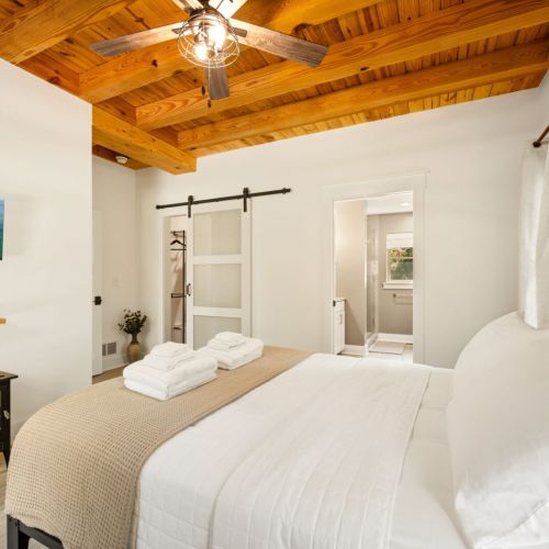 Just off the main living area, the private primary suite offers a comfortable queen bed, TV, cozy fireplace, and an ensuite bathroom complete with a soaking tub and spacious walk-in shower.