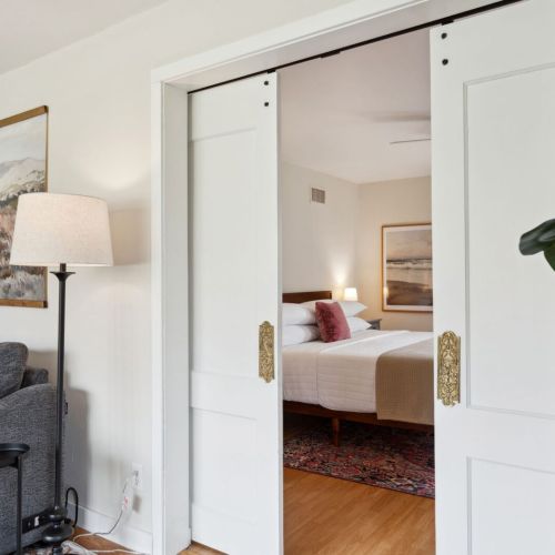 This first-floor bedroom features a king bed and sleek pocket doors that tuck away when open and easily close to create a cozy, quiet retreat.