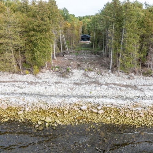 One hundred feet of Green Bay shoreline, accessible for most of the year to those comfortable navigating the natural, uneven terrain. The owner is planning future improvements to enhance accessibility.