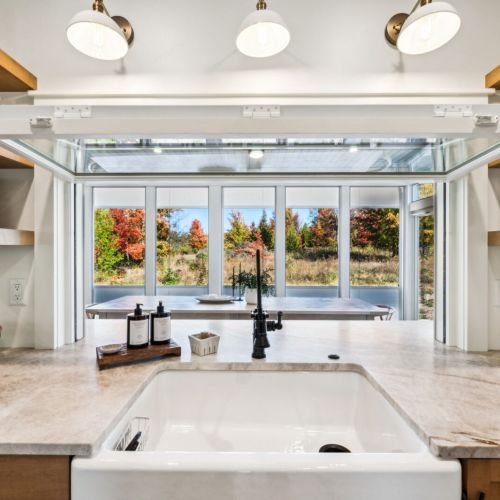 The gourmet kitchen is a chef’s dream, complete with high-end appliances and a fold-up window that opens into the large screened-in porch