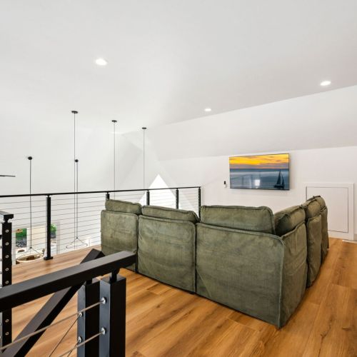 Overlooking the first floor, an additional living area provides a comfortable place of connection with large Smart TV-perfect for streaming your favorite TV shows and movies.