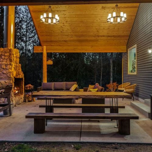 Relish the expansive outdoor living space, featuring a magnificent outdoor fireplace. Share laughter and stories under the starry night sky, enveloped by the tranquil forest setting.