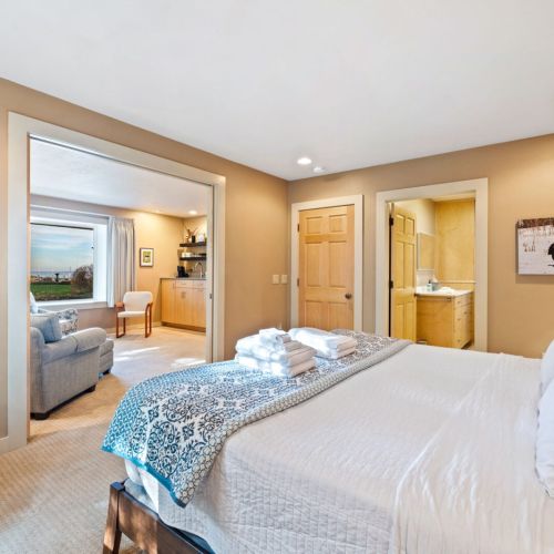 The master bedroom off the main entrance features a king sized bed with plush linens from the Comphy Company.