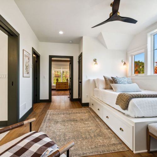 The second bedroom features a comfortable queen-sized bed and serves as a connection point to the spacious double queen bedroom at the far end of the home.